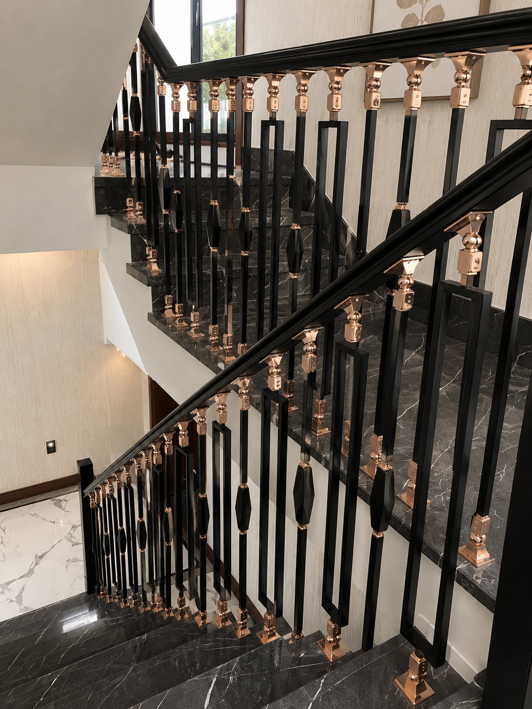 Black stainless steel staircase railing with Rose Gold PVD fittings and geometric rectangular balusters on a luxury marble staircase