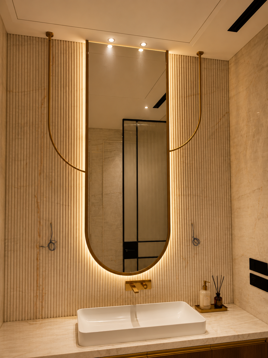 Aurelia U-shaped statement mirror with suspended Antique Bronze PVD stainless-steel arcs in a luxury bathroom