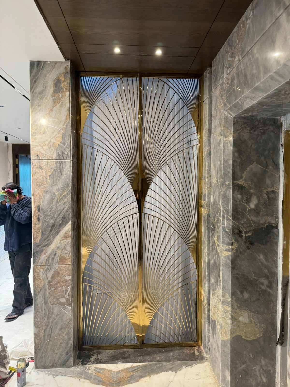 A bespoke ceiling-and-floor-mounted partition combining tall fluted glass panels with circular decorative elements.